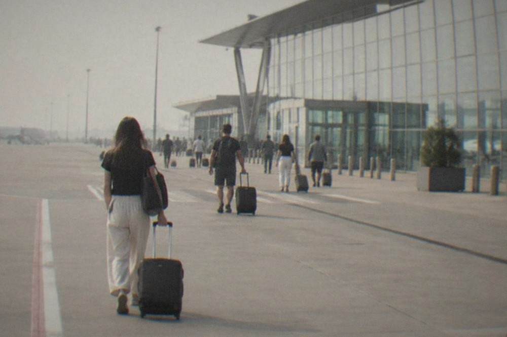 Travelers with suitcases walking through a bright modern airport terminal