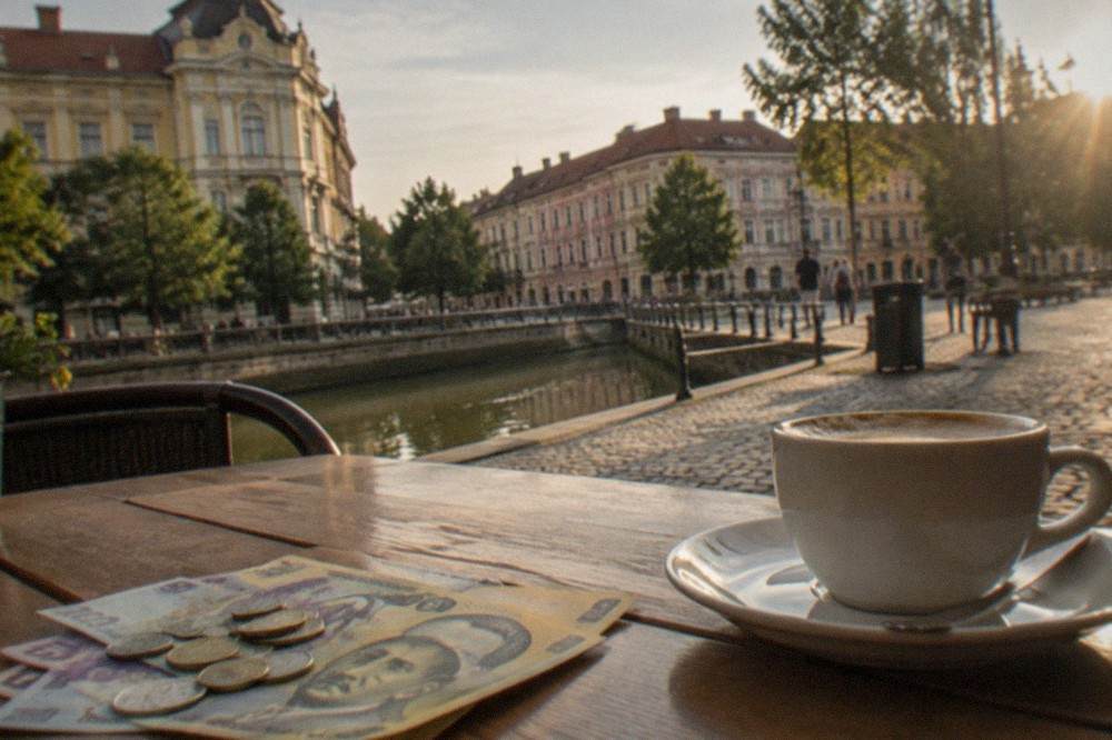 Romanian leu banknotes and coins arranged on a wooden cafe table beside a coffee cup