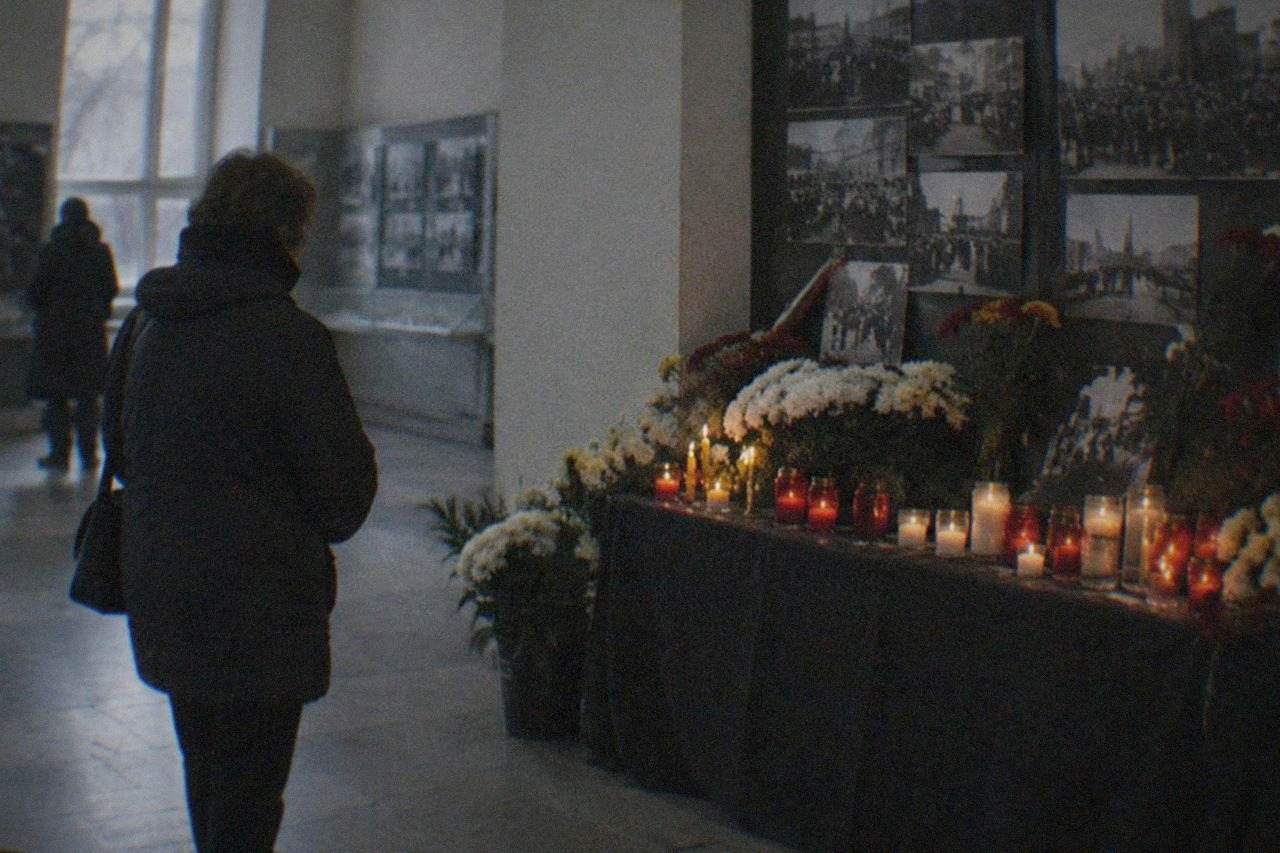 Candlelit memorial corner with photographs and flowers commemorating the 1989 revolution