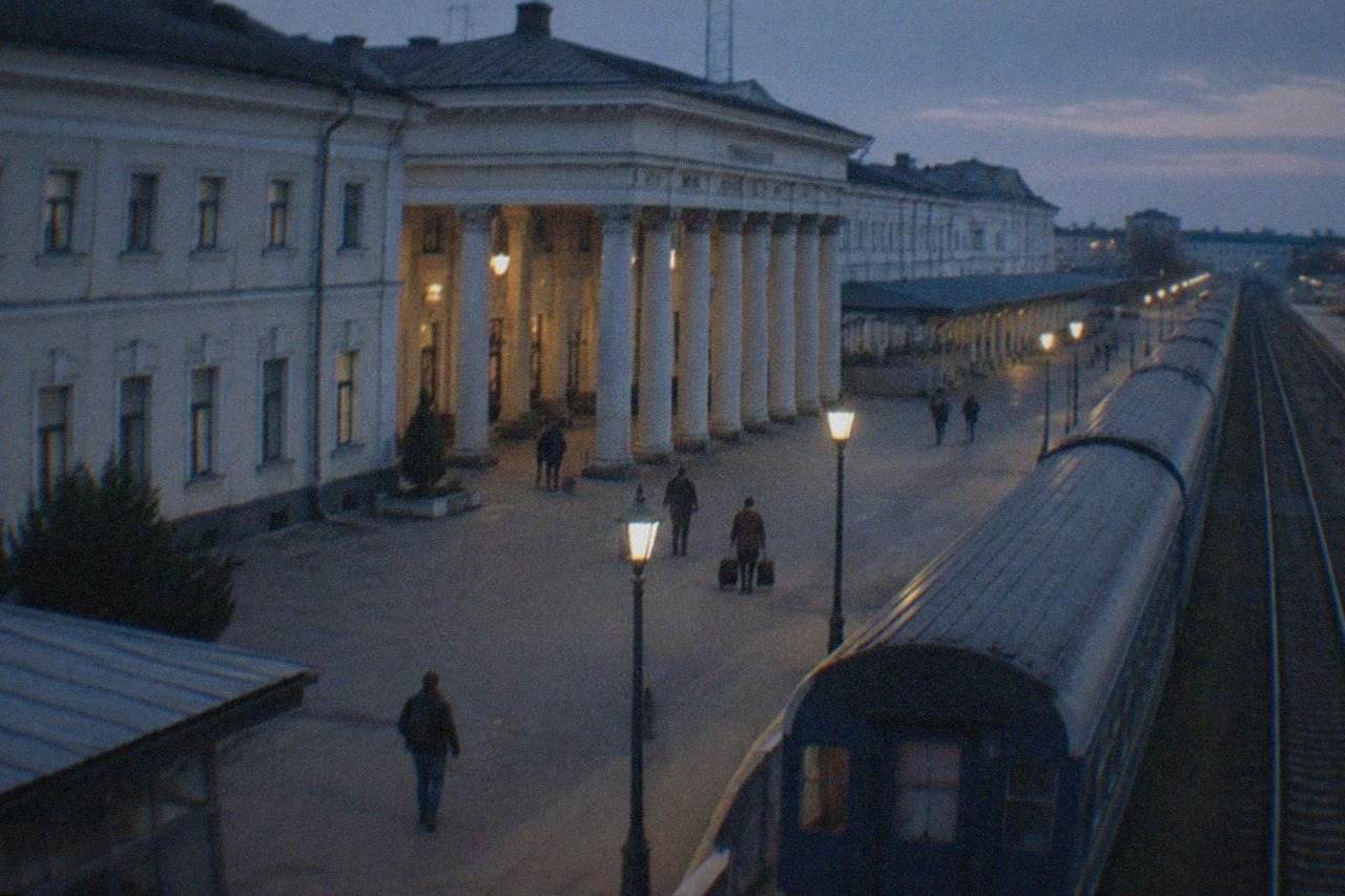 A passenger train standing at a platform of a Romanian railway station