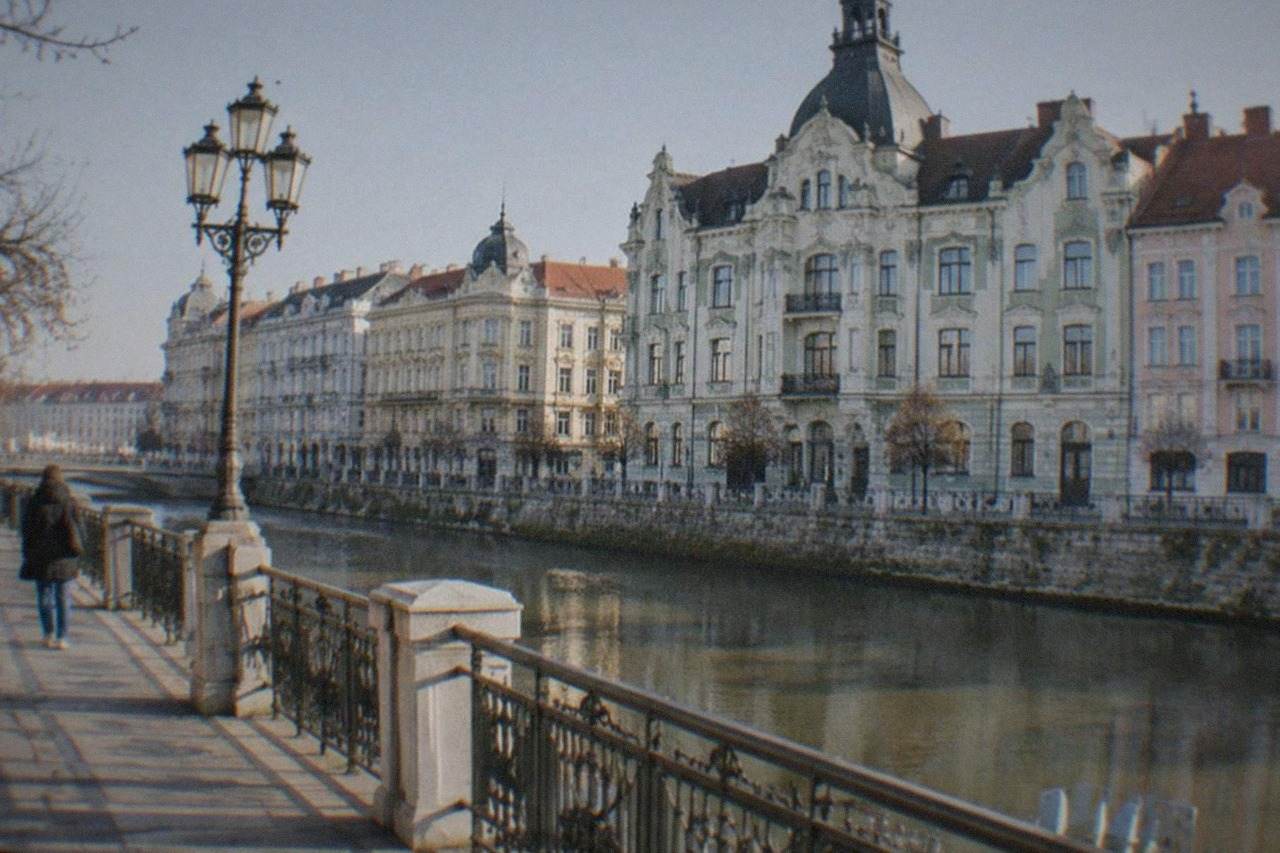 Ornate Art Nouveau building facades in bright daylight along a city square in Oradea, Romania