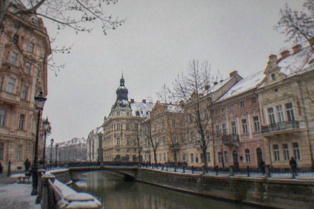 A winter street scene in an old European city center with decorated facades