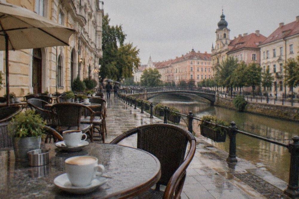 A café terrace beside a historic building with cups of coffee on the tables