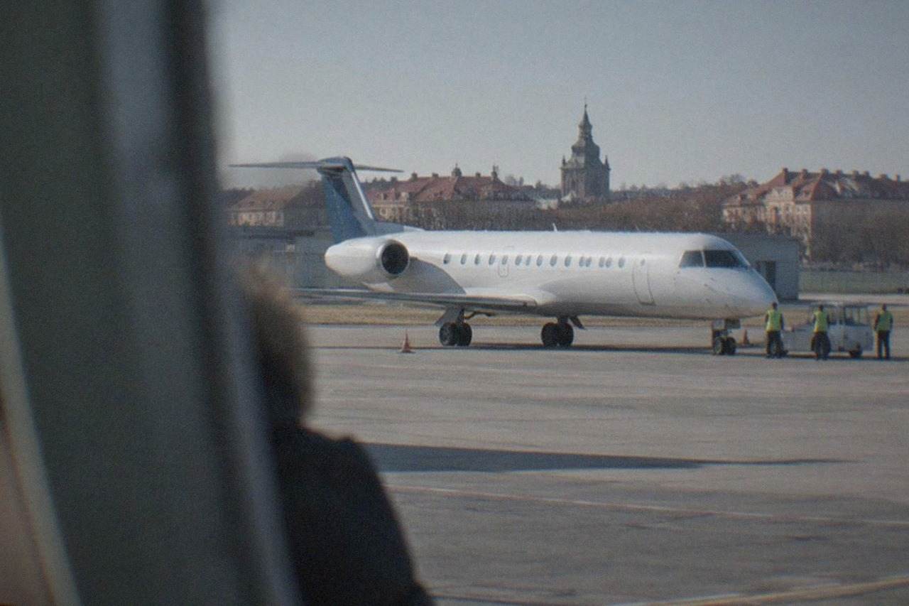 A commercial airplane on the apron of a small regional airport under a clear sky