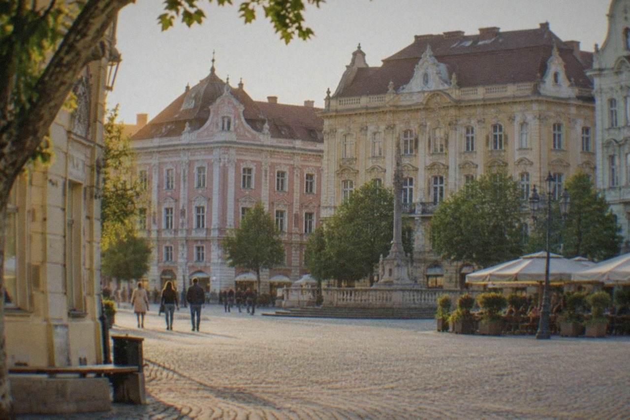 Colorful baroque buildings around a square in Timisoara's old town at golden hour