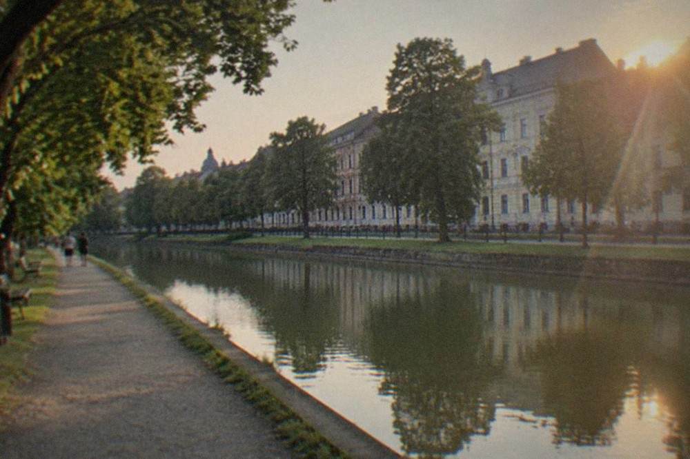 The Bega canal in Timisoara with a promenade, trees and historic buildings along the bank