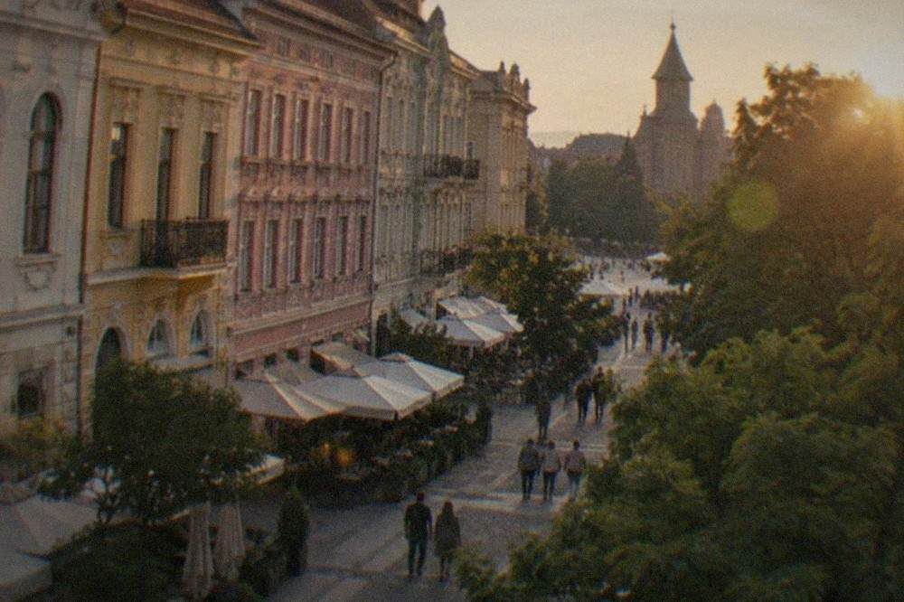 Colorful facades and cafe terraces along a pedestrian street in Timisoara's old town