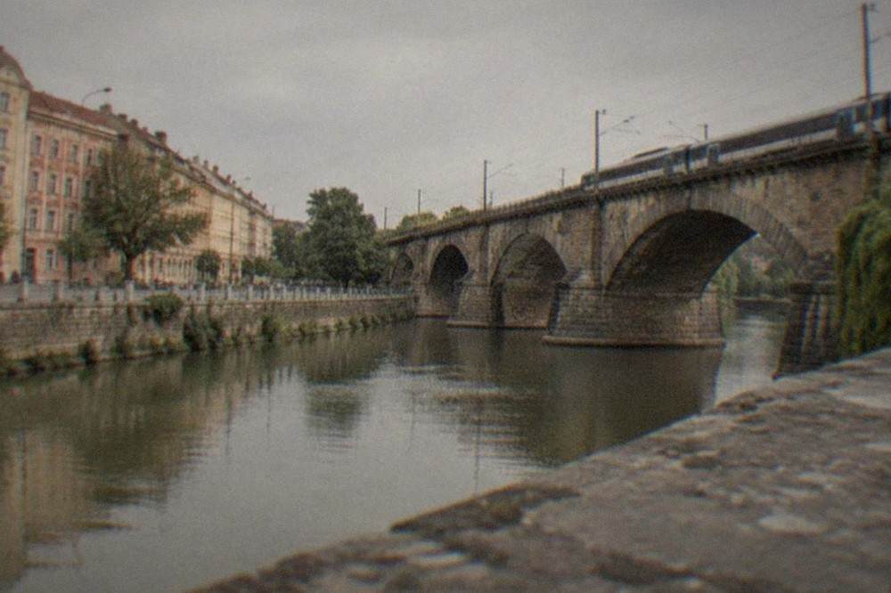 Sunlight falling on an old railway viaduct above a river in the Caras-Severin hills