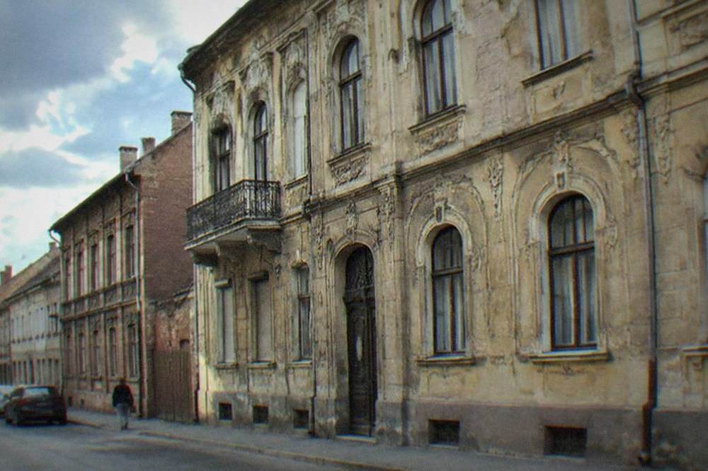 A Secession-style apartment facade with ornate windows and stucco decoration on a Fabric street
