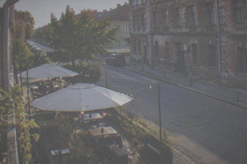 A cozy neighborhood cafe terrace on a Fabric street in the evening