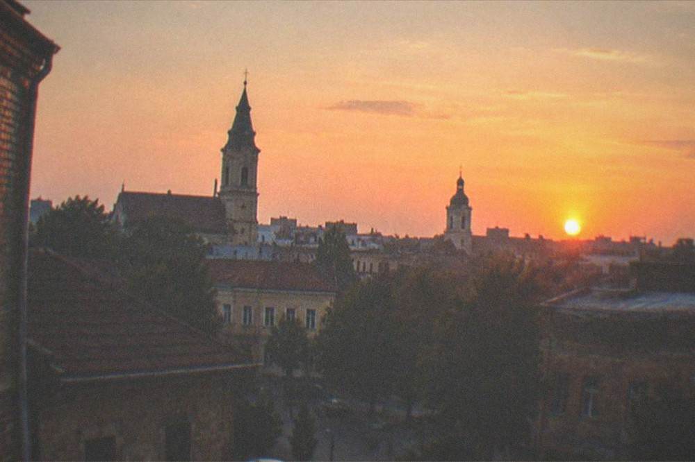 Sunset over the rooftops and church towers of the Fabric district seen from a distance