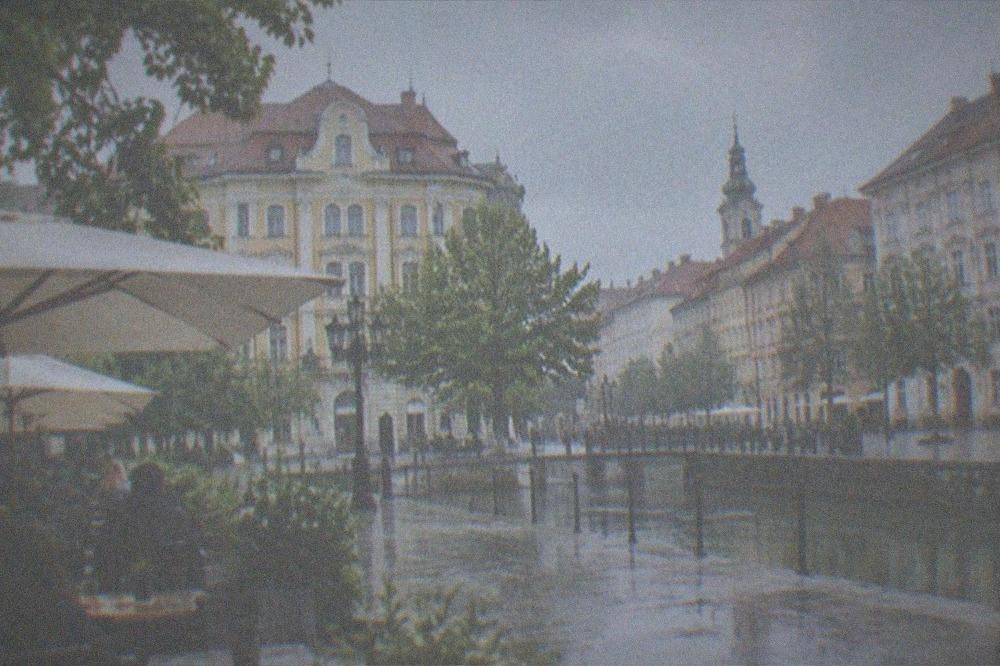 Outdoor cafe terrace with people seated at tables on a city square
