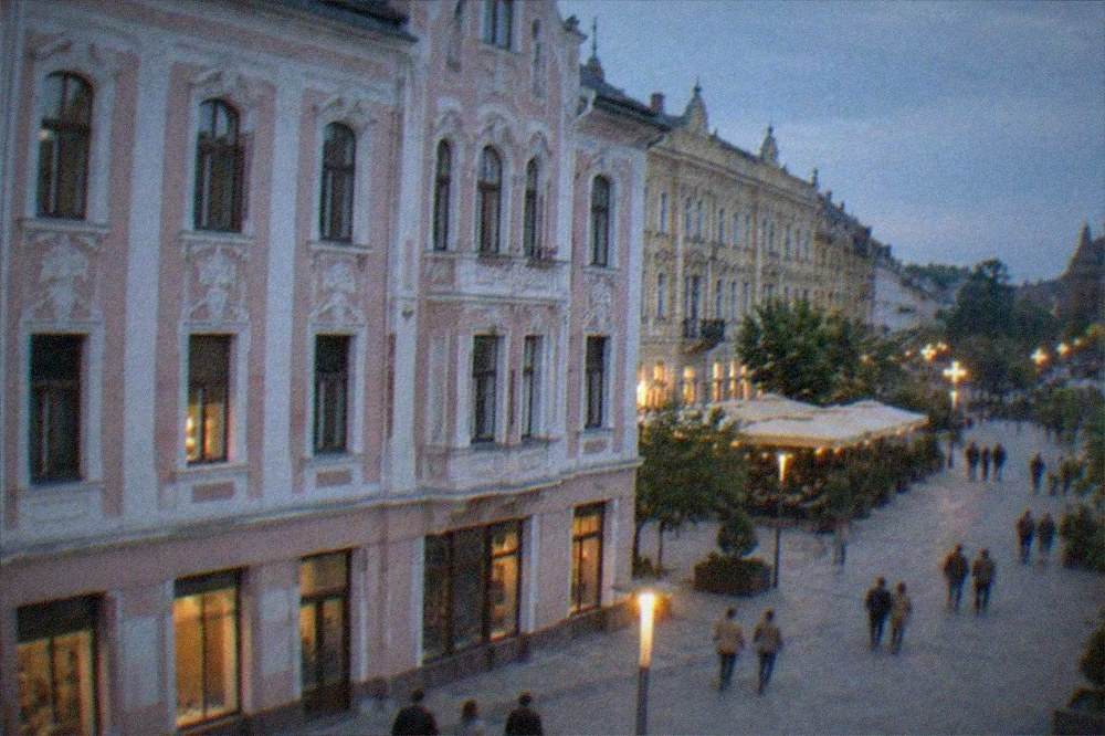 People strolling past historic facades on a wide pedestrian boulevard
