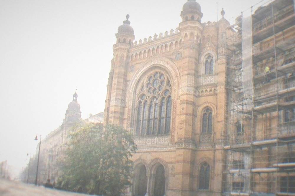 Restoration scaffolding on a historic building facade with workers' equipment visible