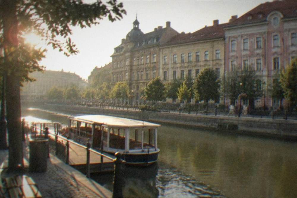 Canal promenade in Timisoara with a small passenger boat moored at a dock
