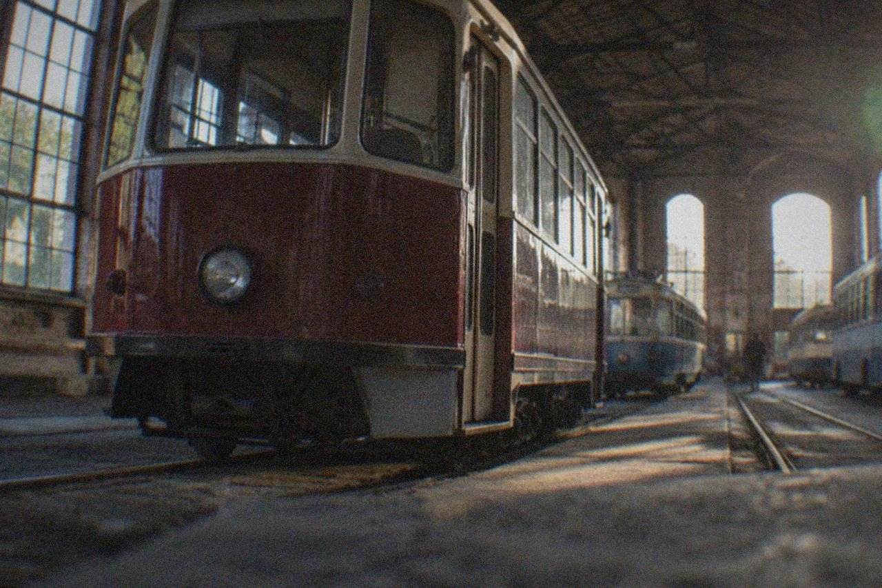 A vintage tram parked inside a brick railway depot that now serves as a transport museum