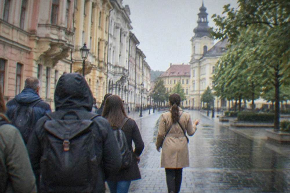A guide leading a small group of visitors along a pedestrian street in the old town