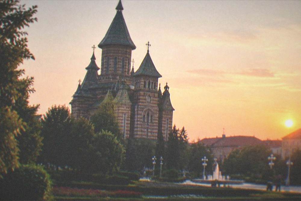 The cathedral tower rising above the rooftops of the city at dusk