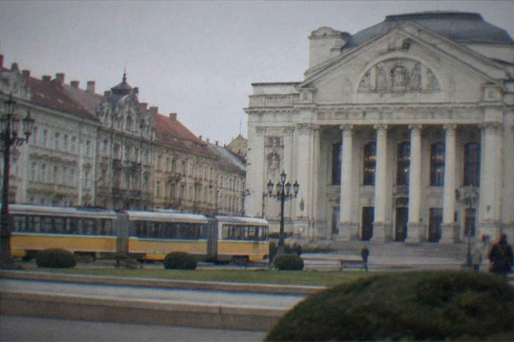 A tram passing a row of ornate facades near the city center