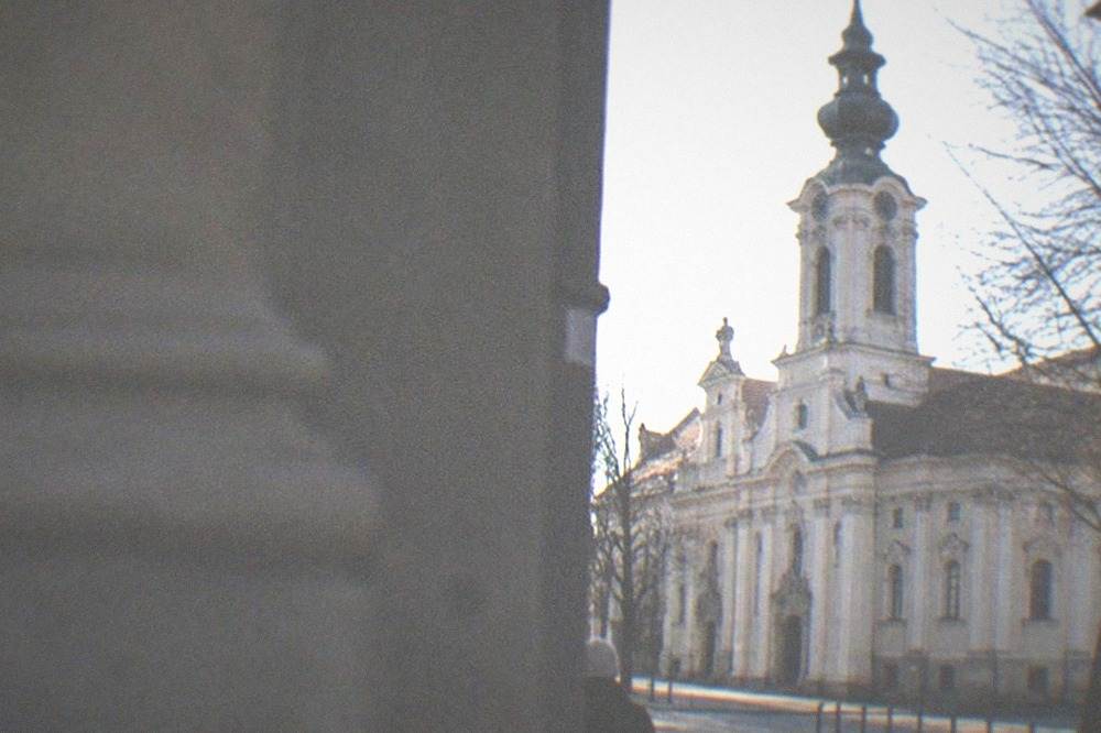 Historic church facade with baroque ornament beside a quiet city street