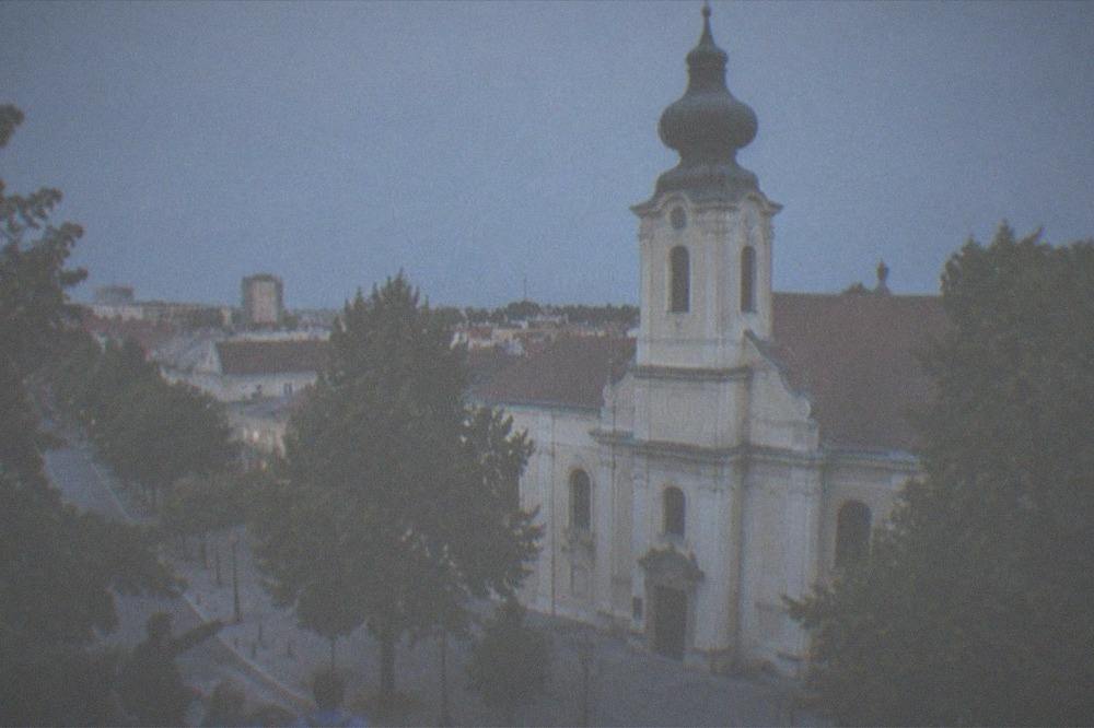Guide pointing out details on an old church to a small group of visitors