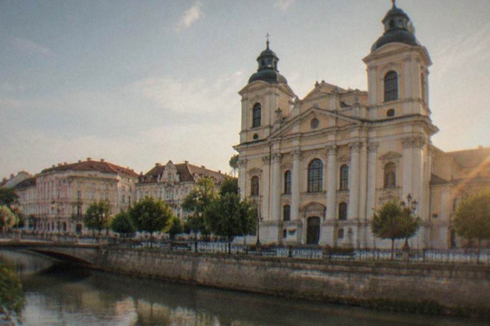 Close view of the cathedral's classical facade with columns and tall windows in Timisoara