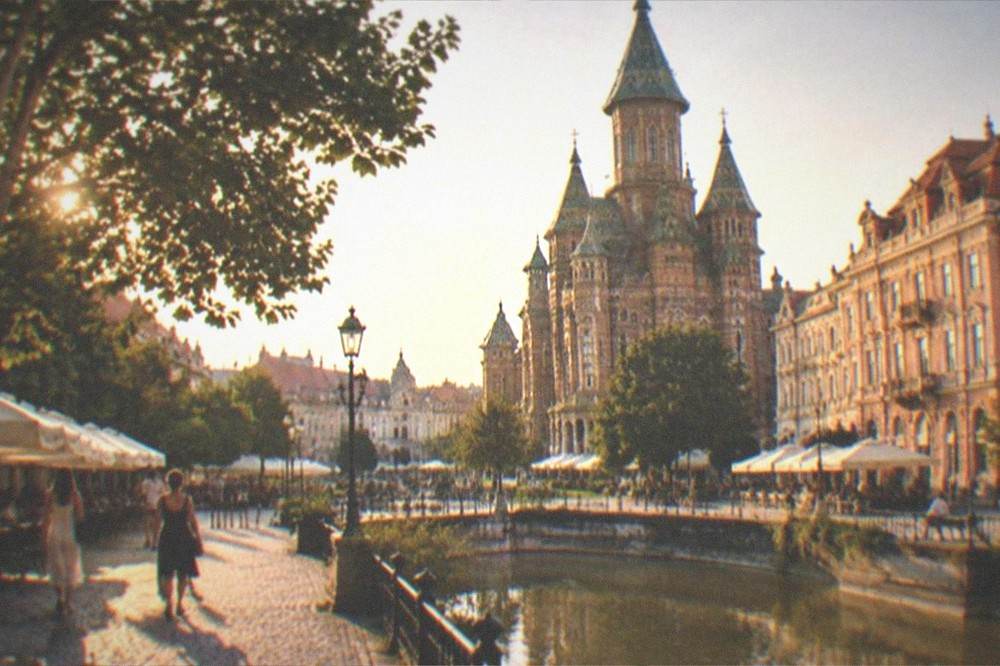 The cathedral and square under a summer sky with cafe umbrellas in Timisoara