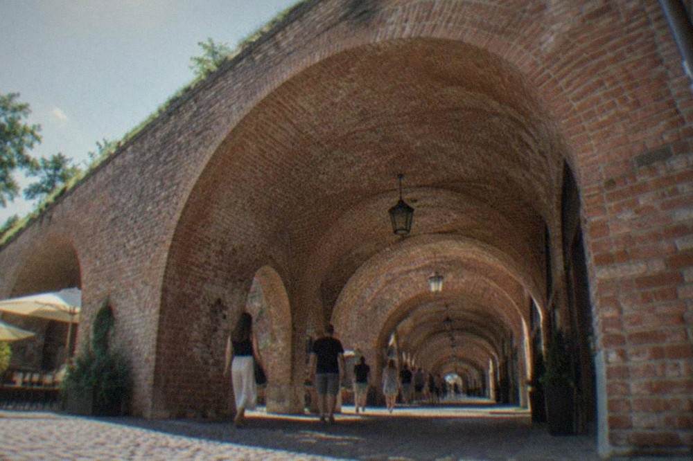 Visitors walking through the arched interior corridor of the Theresia Bastion