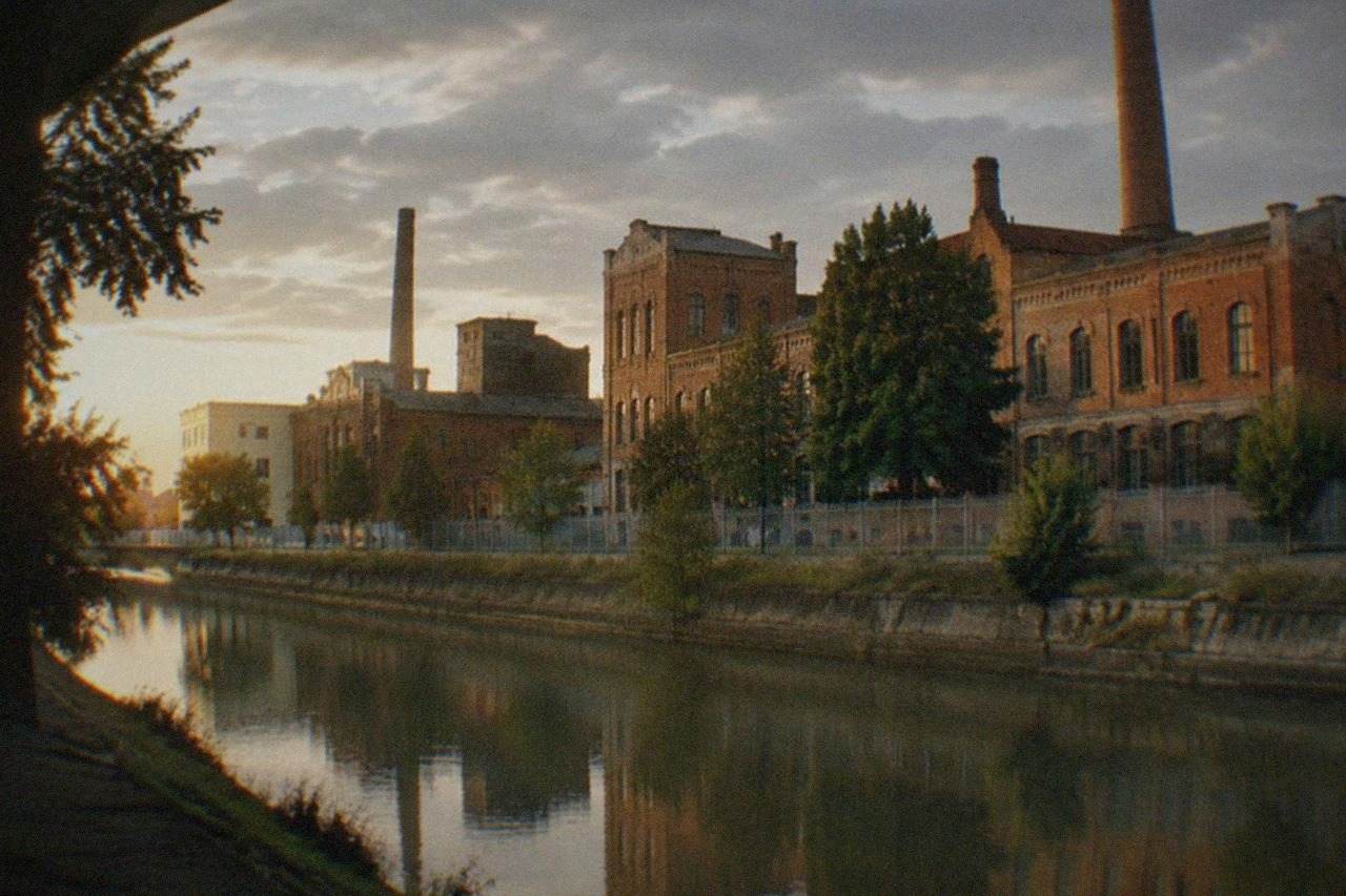 Historic brewery buildings beside a canal in Timisoara at golden hour