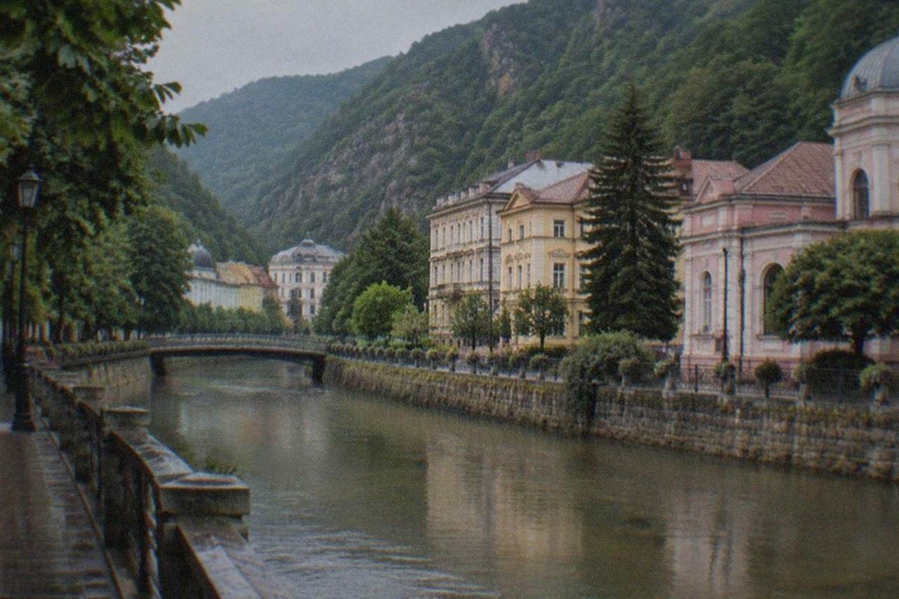 Thermal spa buildings in a narrow mountain valley with forested slopes rising on both sides