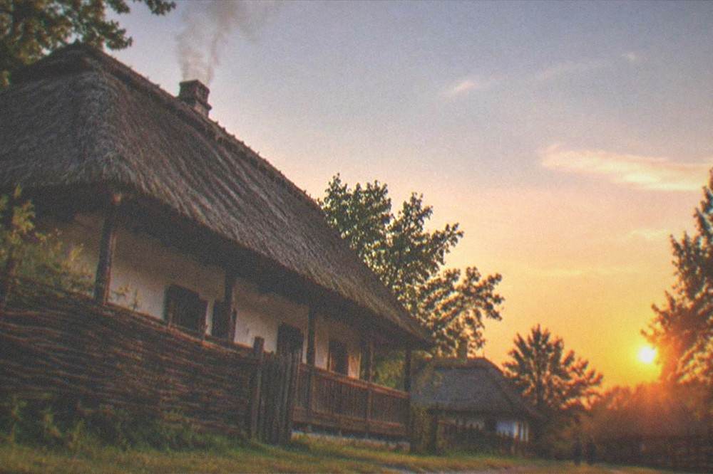 Sunset over a Banat village with smoke rising from a chimney