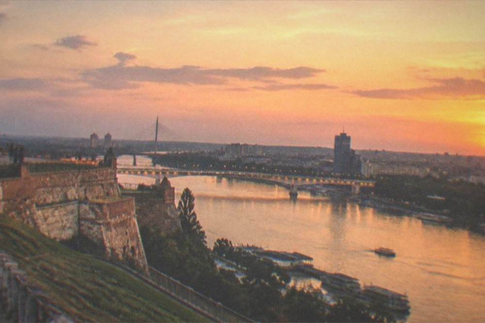 Evening view of a city skyline with lit bridges spanning a wide river