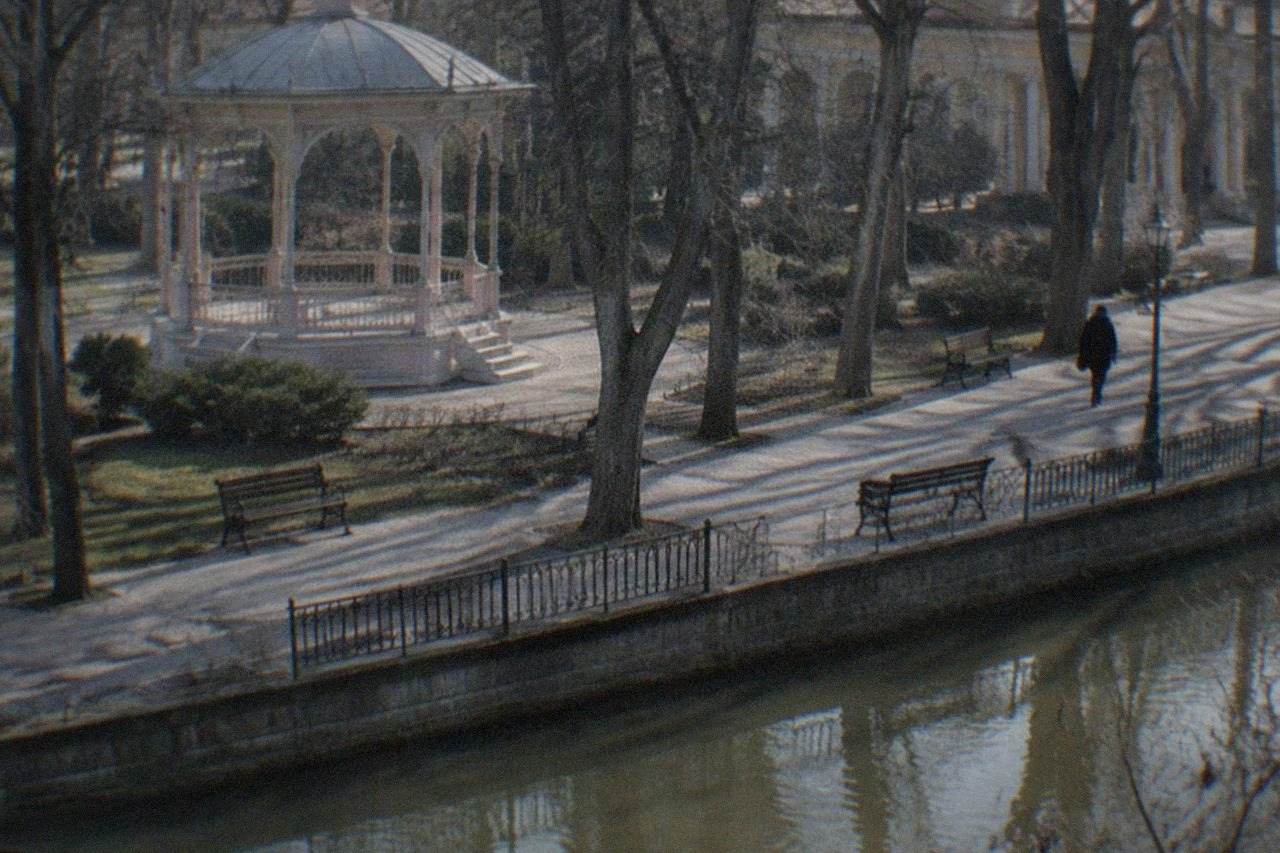 A tree-lined promenade in a small Banat spa town with ornate colonnades in the background