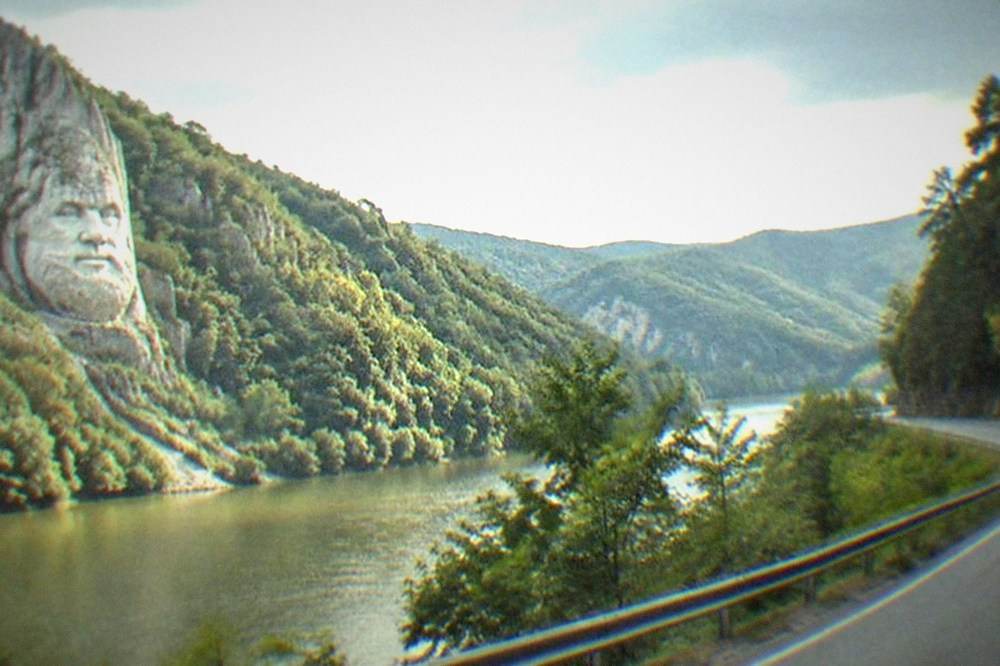 A winding road through green forested hills in southwestern Romania