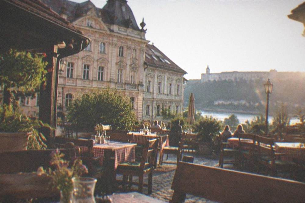 A traditional Serbian kafane courtyard with wooden tables set for lunch