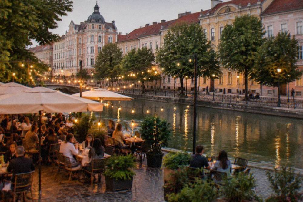 An evening restaurant terrace in a Timisoara square, with string lights and people at tables