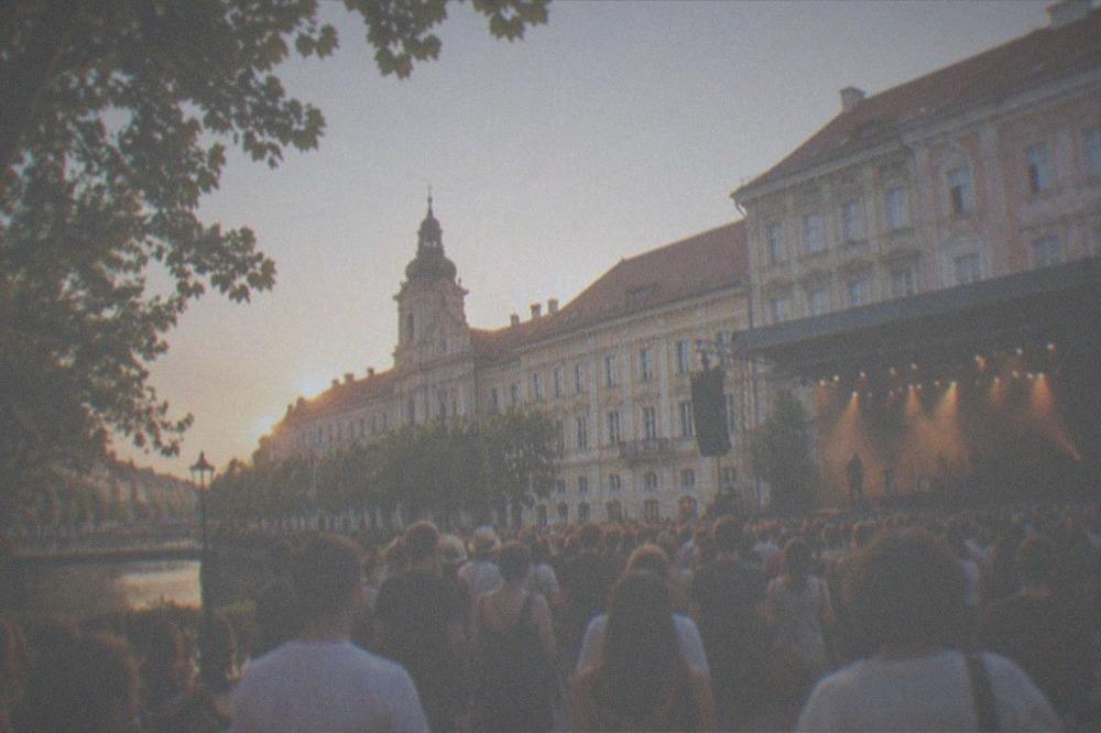 Open-air concert crowd in a Timisoara square at dusk in summer