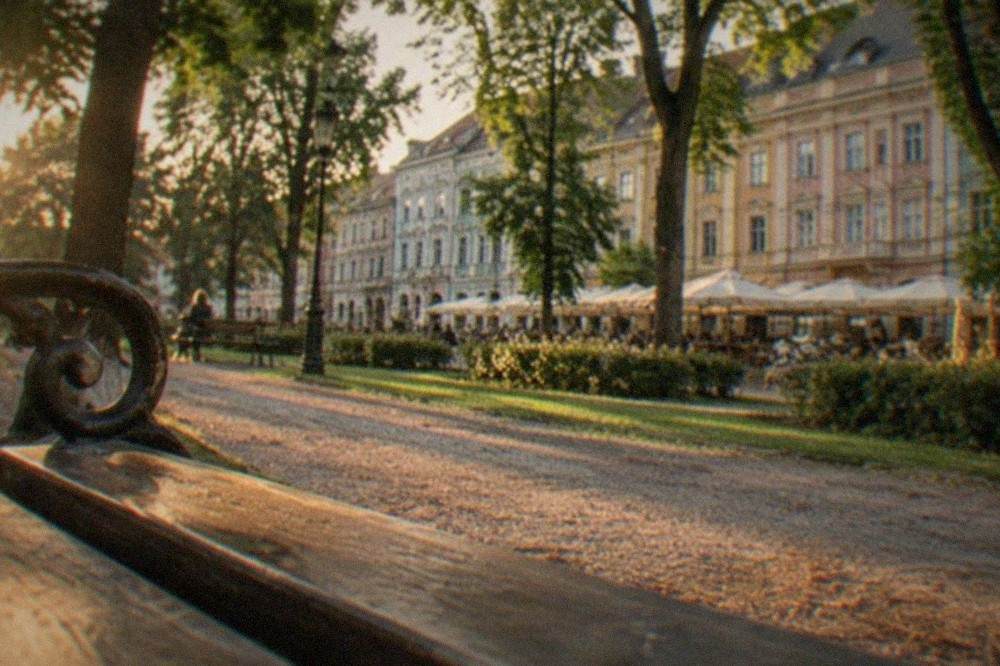 Pastel-colored historic facades lining a pedestrian square with outdoor cafe tables