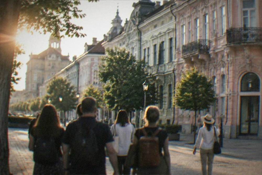 Small group of visitors following a guide along a pedestrian street in an old town