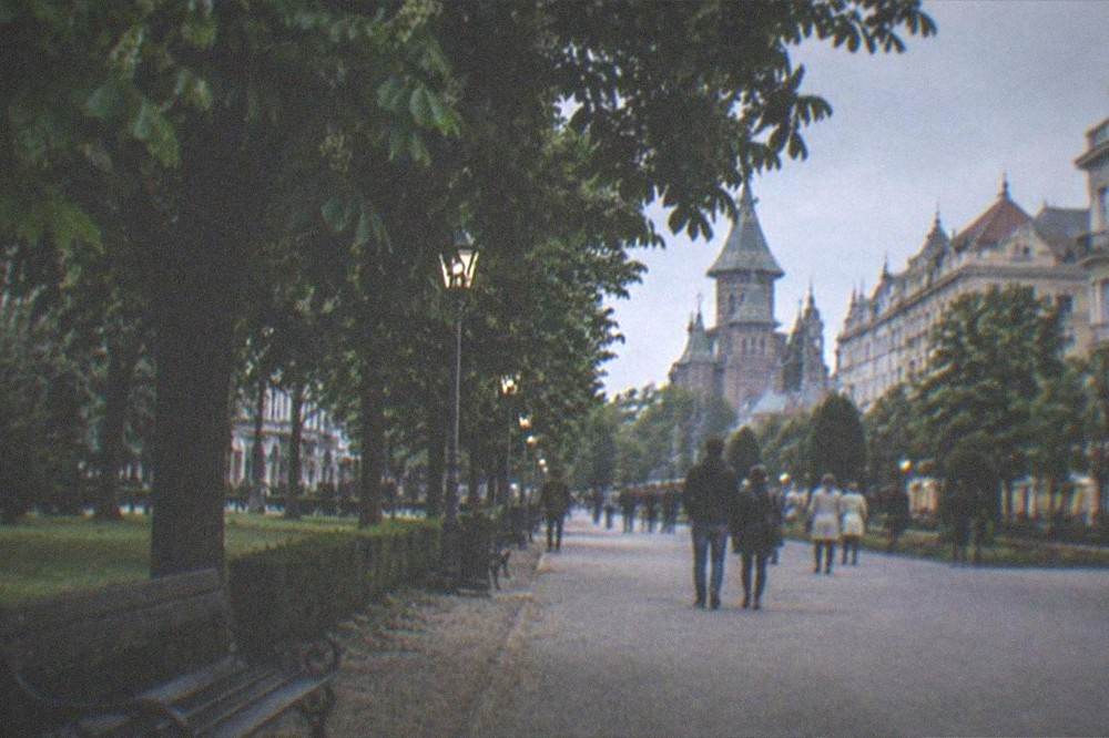 Wide pedestrian boulevard with historic buildings and people strolling in evening light