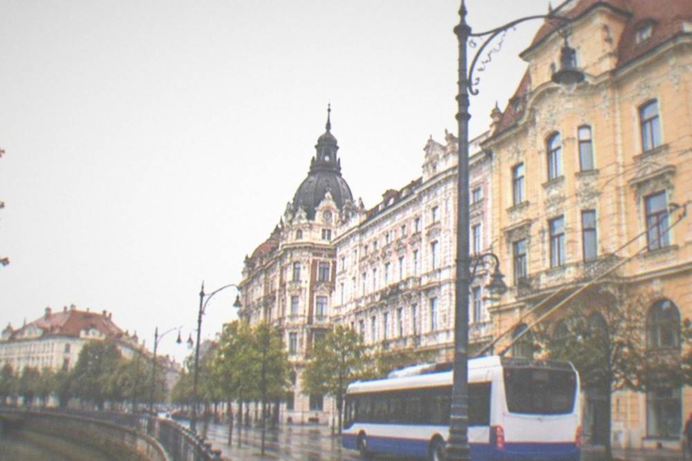 A trolleybus passing grand buildings on a boulevard in Timisoara