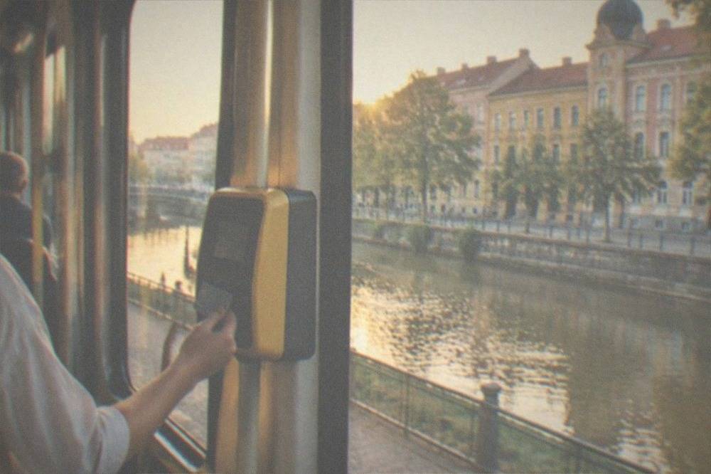 A passenger tapping a bank card on a validator inside a tram