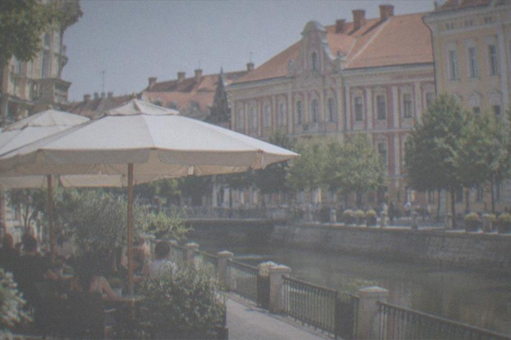 An umbrella-covered cafe terrace on a sunny street in Timisoara