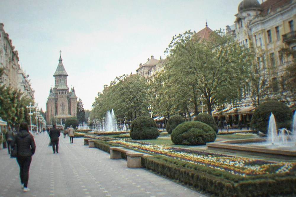 Visitors walking across a historic square toward a baroque cathedral facade