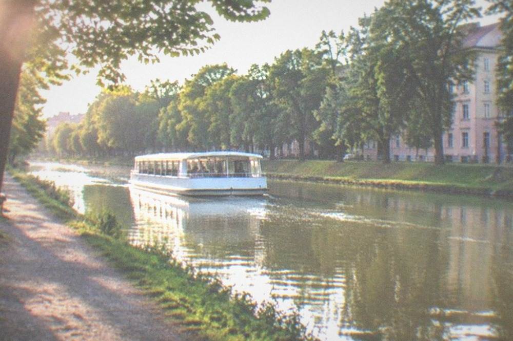 A white water bus cruising the Bega canal between green banks