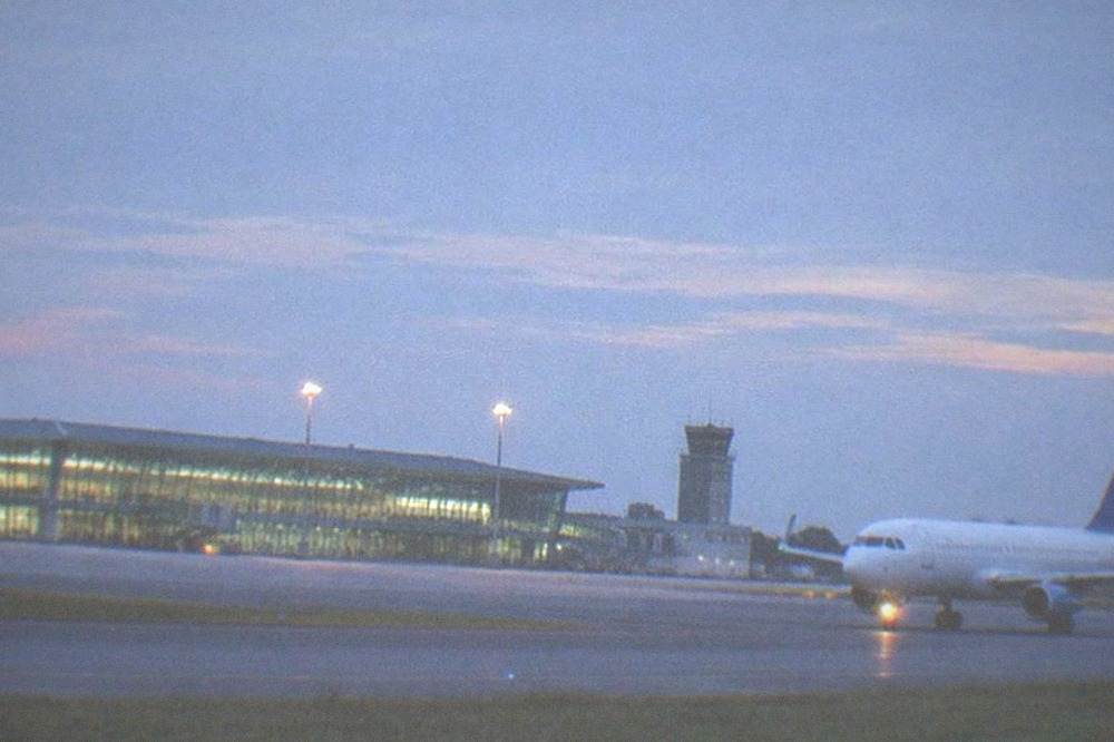 A passenger plane taxiing on a runway at dusk