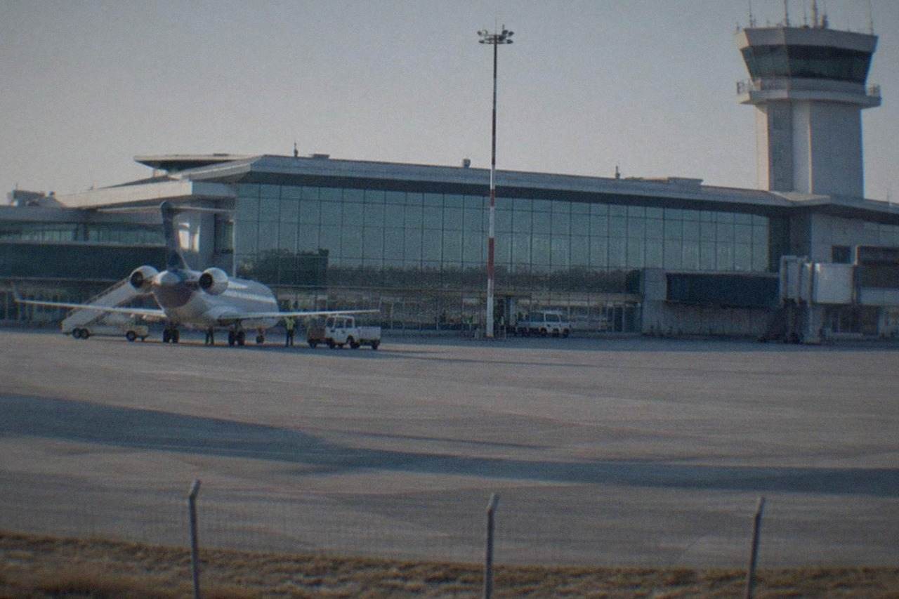 Airport terminal building with a control tower under a clear sky