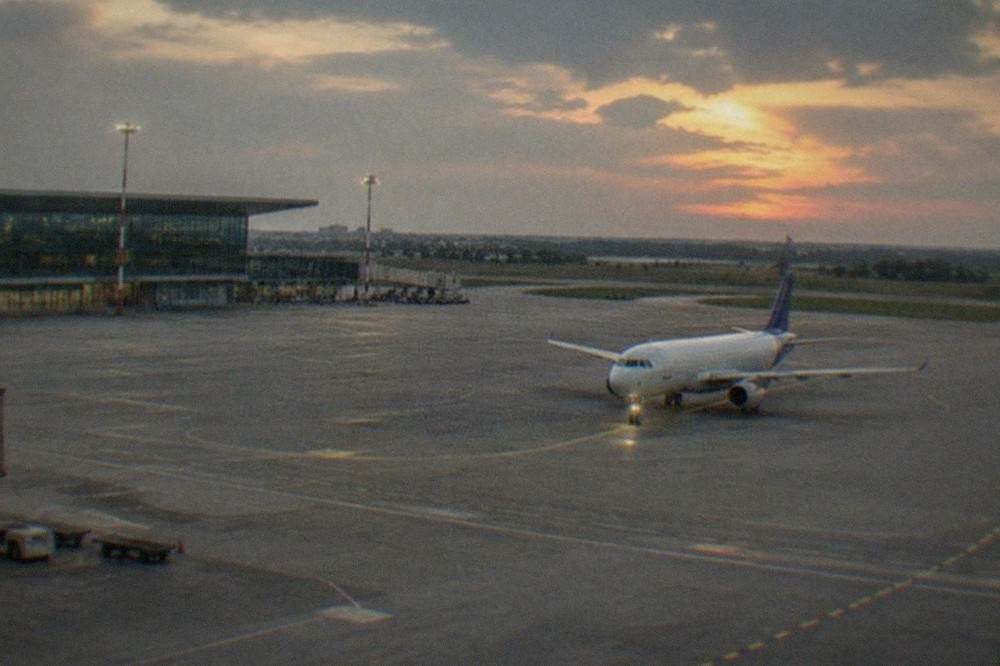 A low-cost airliner taxiing on an airport apron at dusk