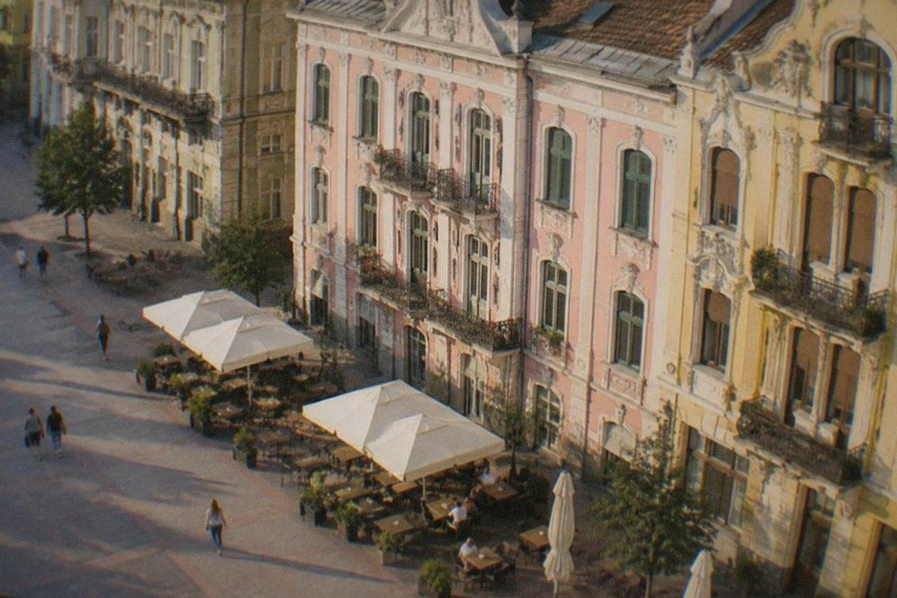Baroque and Secession facades lining a pedestrian square in Timisoara at golden hour