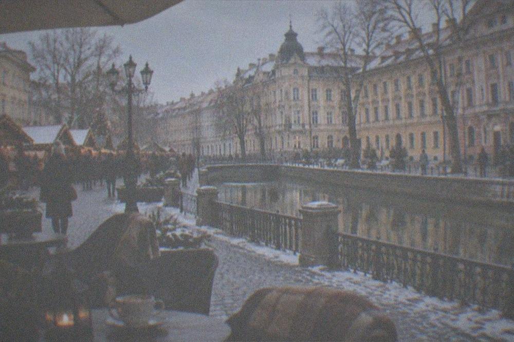 A winter cafe terrace with blankets and warm drinks near a Christmas market in Timisoara